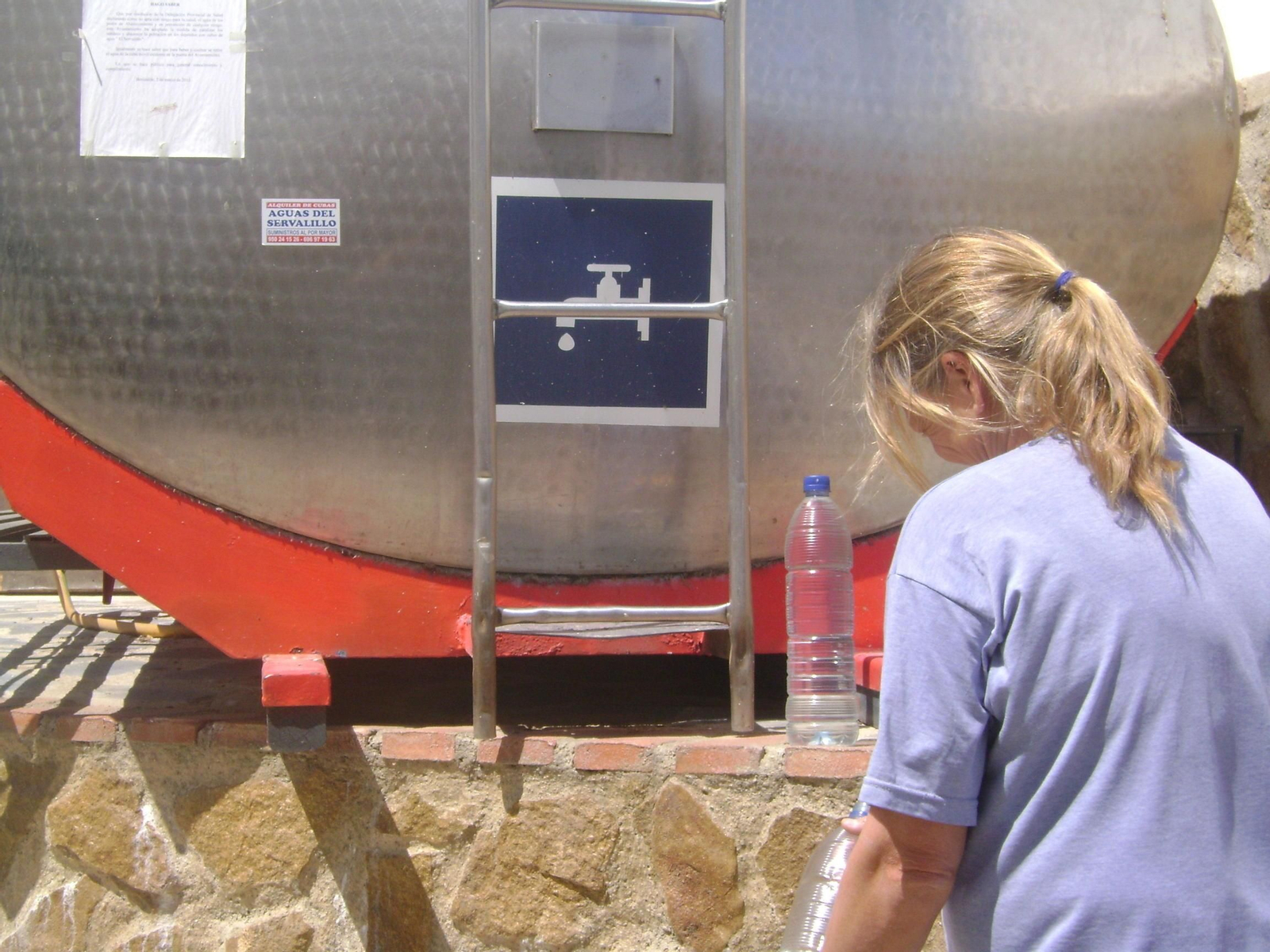 Una vecina de Benizalón utiliza la cuba  de agua .