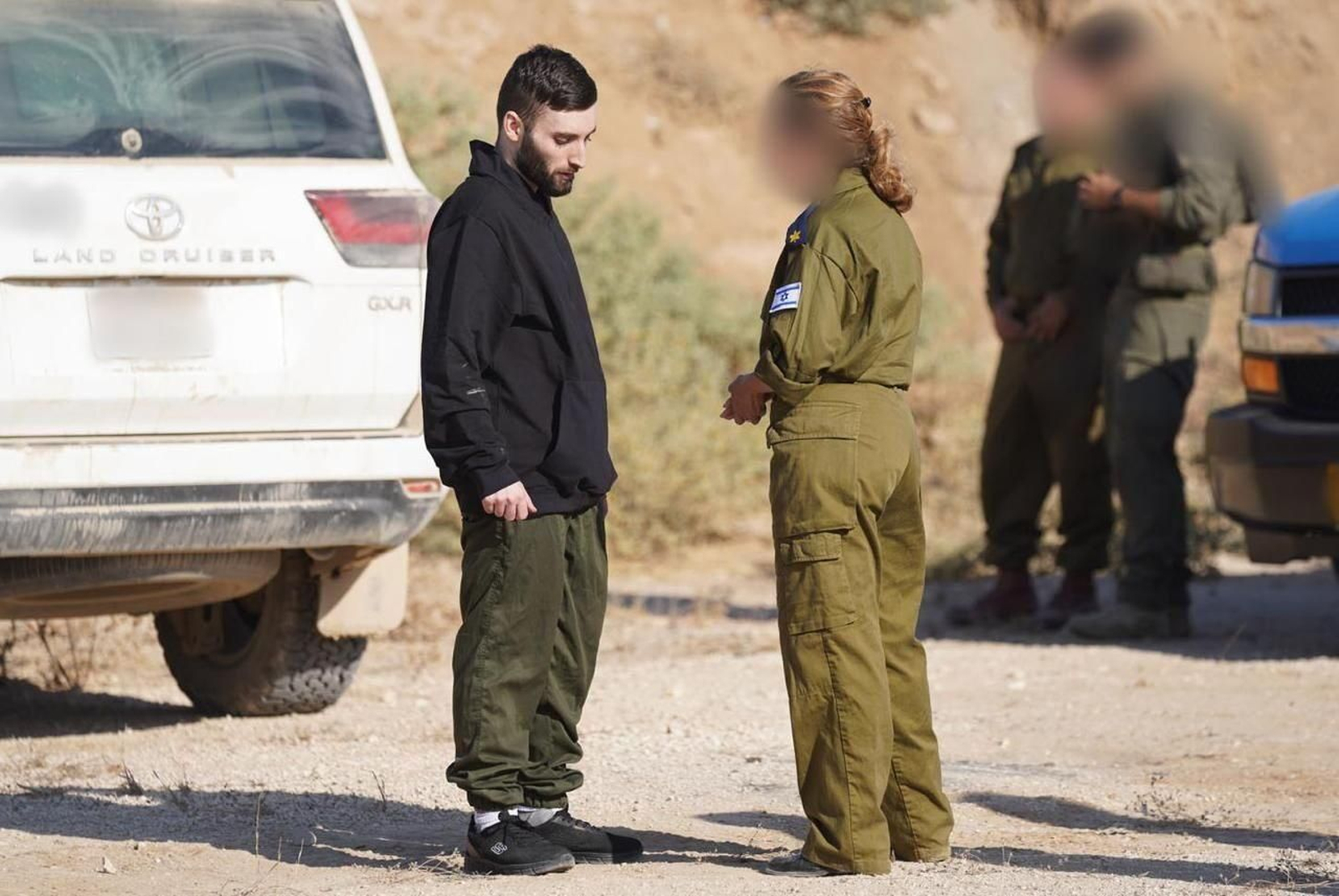 Una militar habla con Matan Angrest, uno de los rehenes liberados.