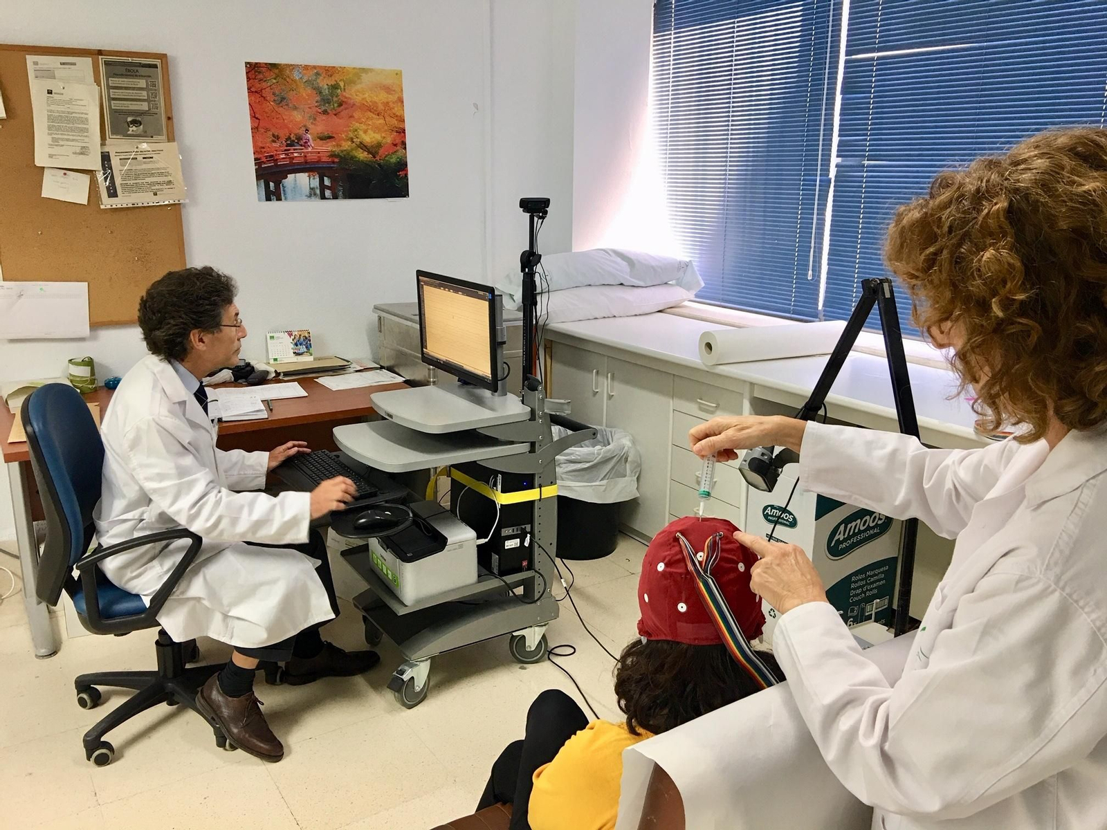 Manuel Romero y una sanitaria del Servicio de Neurología durante un electroencefalograma.