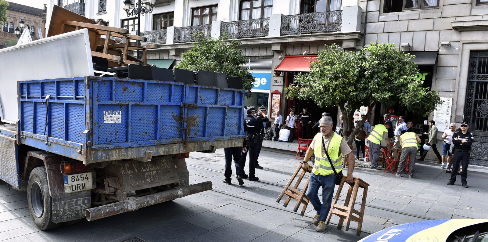 Técnicos municipales retiran las mesas y sillas de un local en la Avenida.
