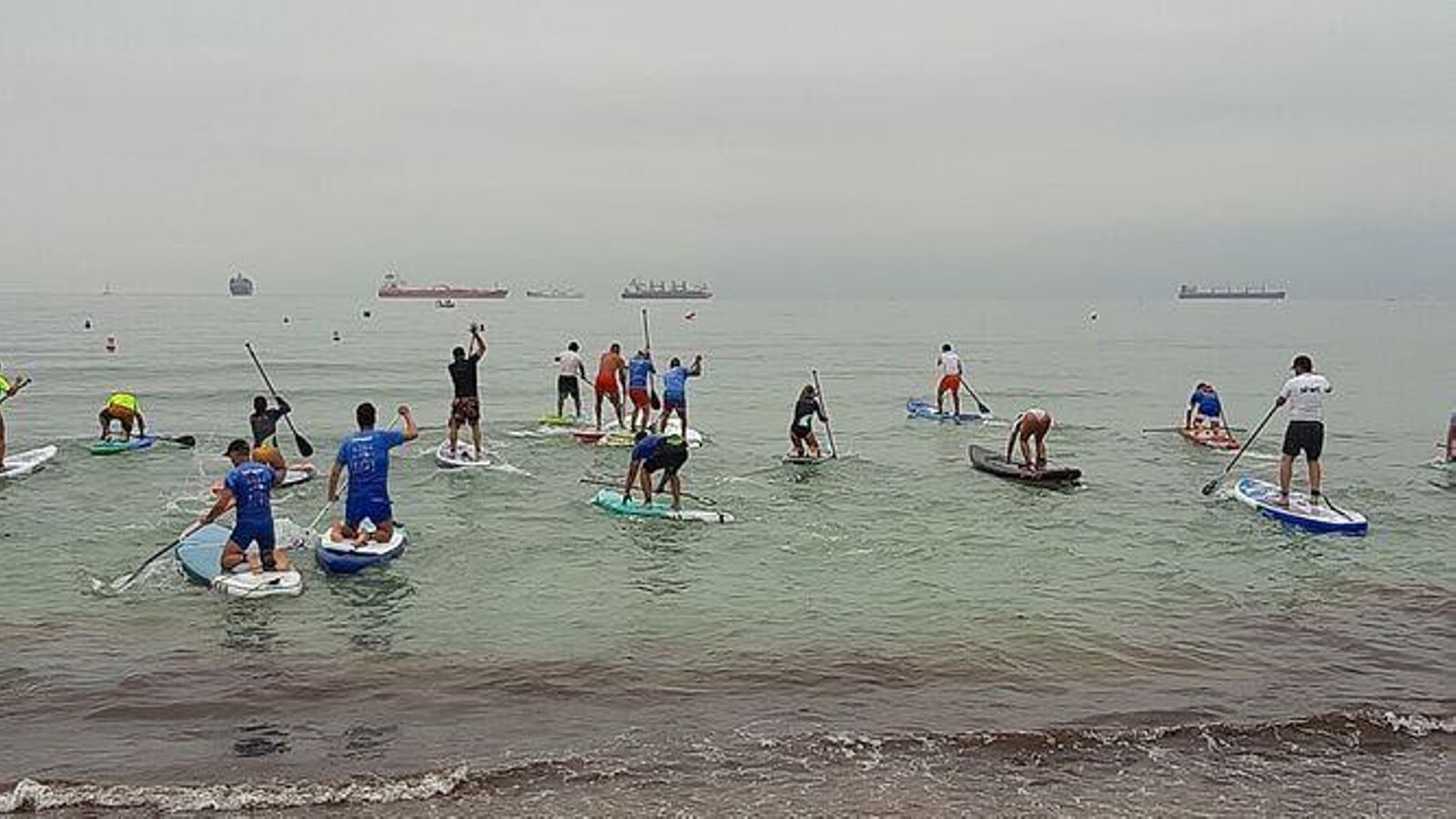 Un grupo de personas disfrutan del Paddle Surf en Getares