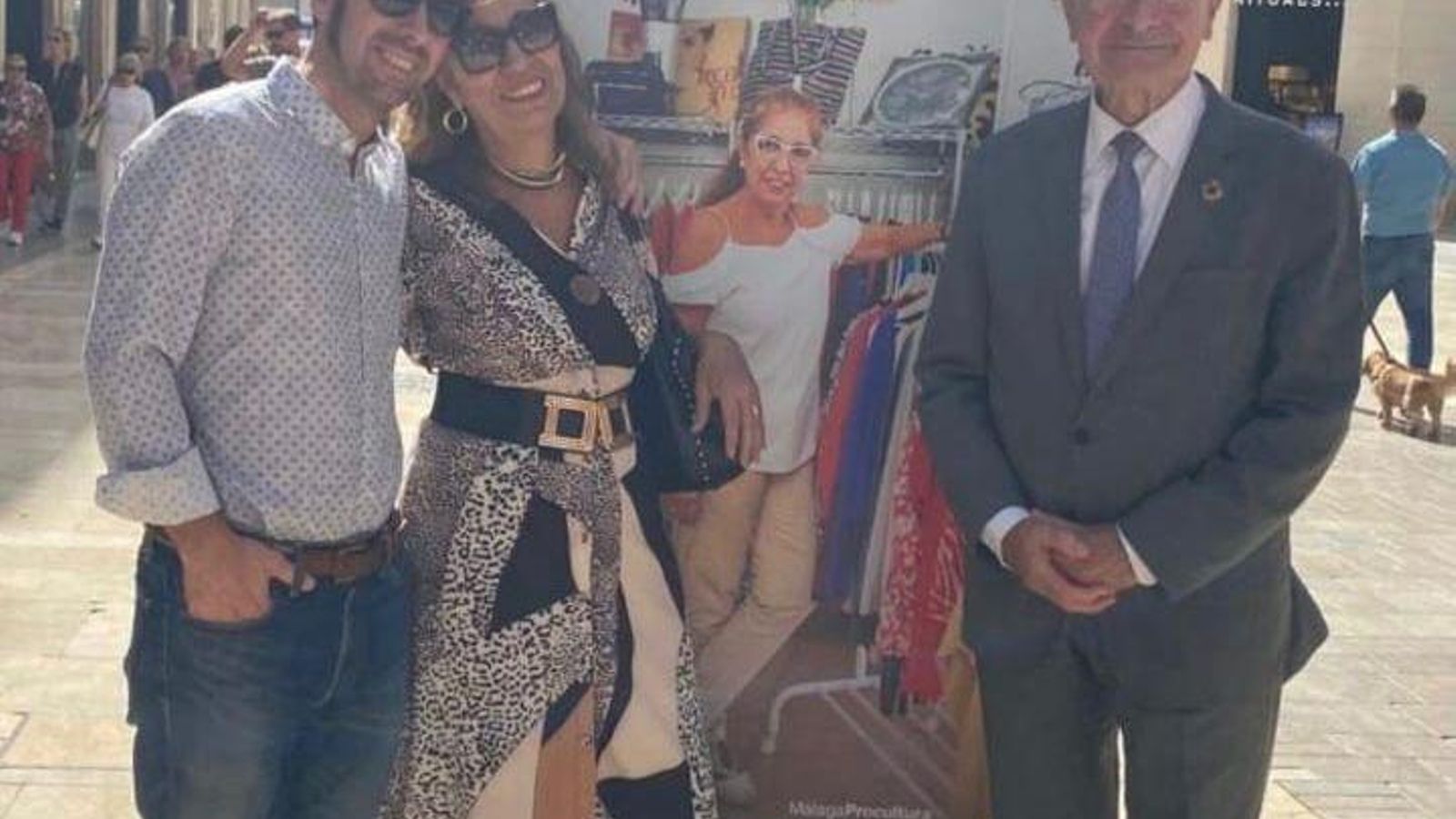Helena Olaso, su hijo Salvador y Paco de la Torre, alcalde de Málaga, posando junto a un cartel del Siglo XX ubicado en la Calle Larios