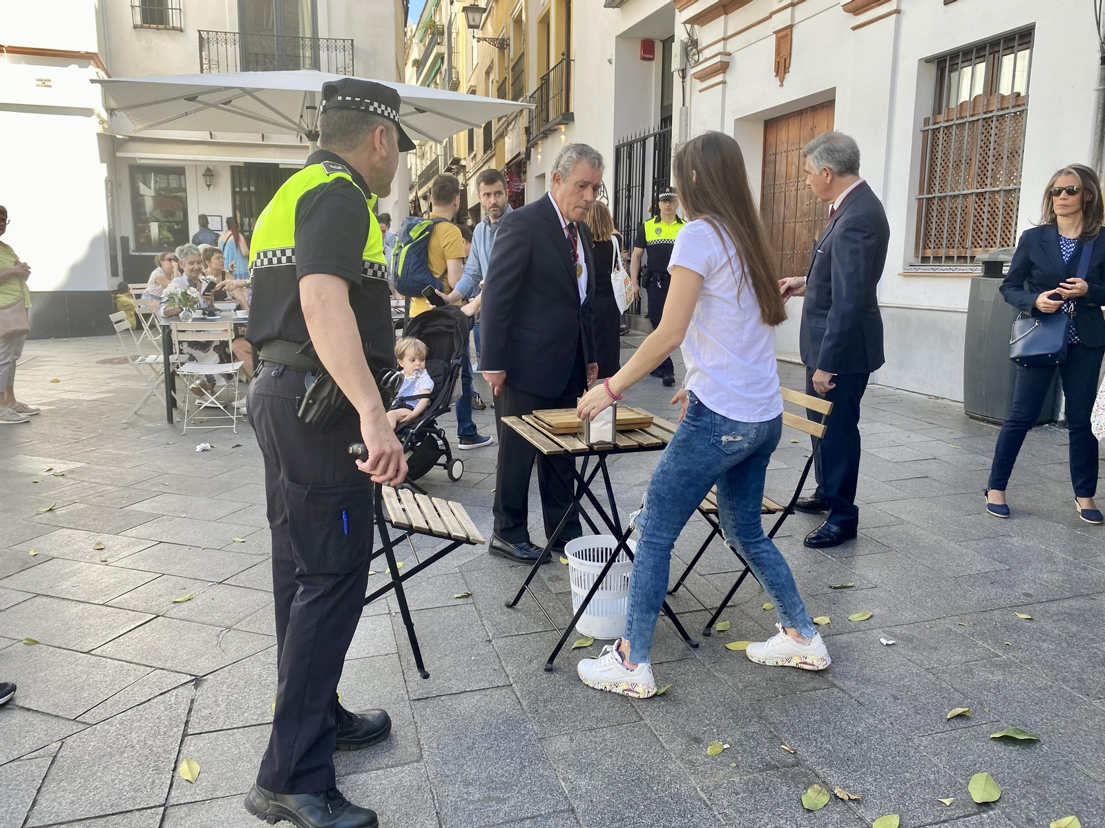 Hermanos de la Archicofradía del Sagrario y policías locales retiran veladores para facilitar el paso de la procesión de impedidos el pasado domingo.