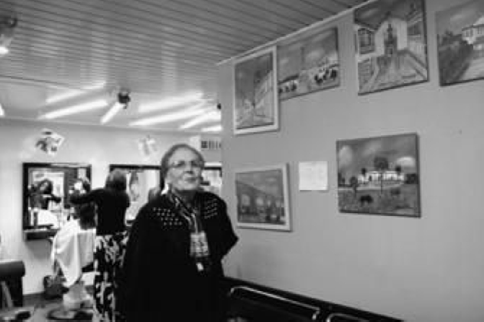 Josefina Moreno posa con algunos de los cuadros que tiene expuestos en la peluquería Raimundo.