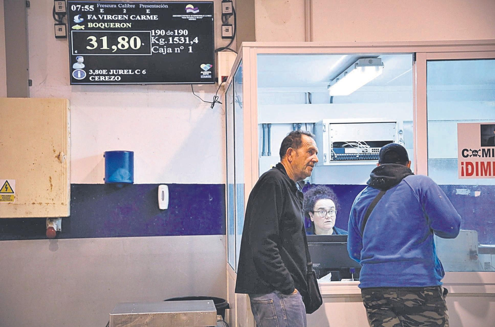 Paco, armador del Punta Isleta, y Bartolo, comprador, conversan con Reme durante la subasta del pasado jueves.