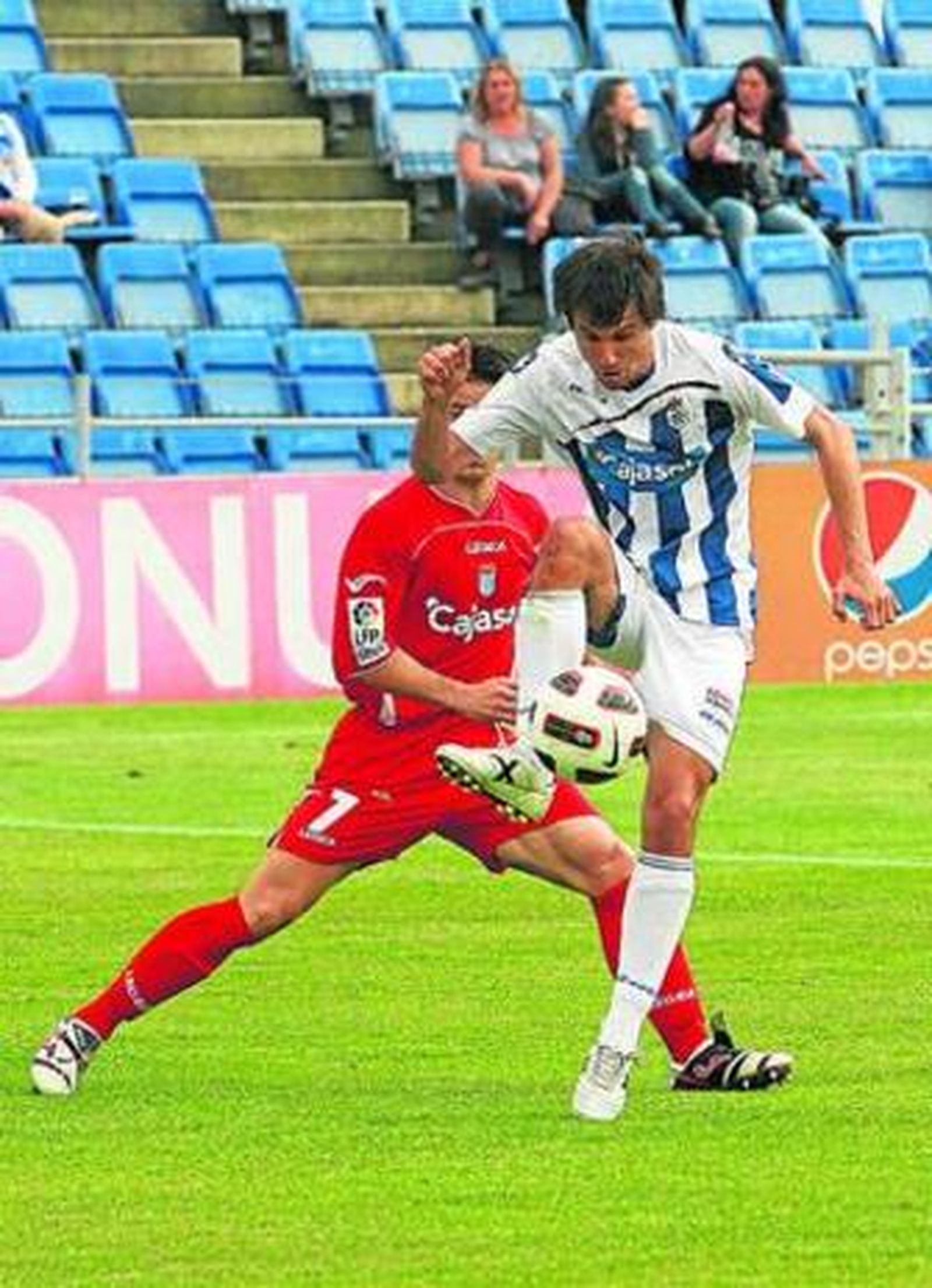 Asen controla el balón con Edu Moya presionándolo.