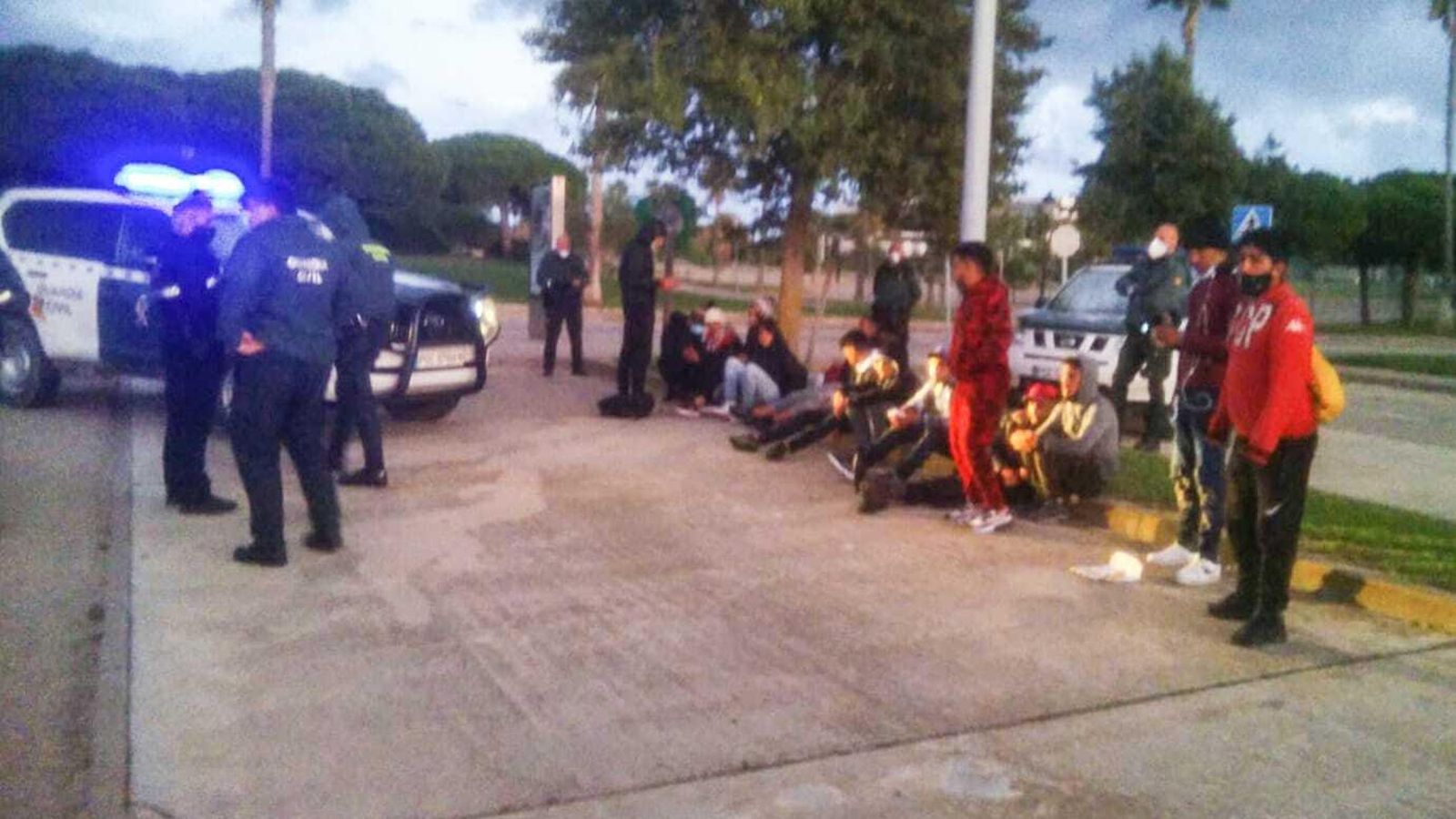 Agentes de la Guardia Civil y de la Policía Local, junto a los inmigrantes llegados hace unos minutos al Novo en una patera.