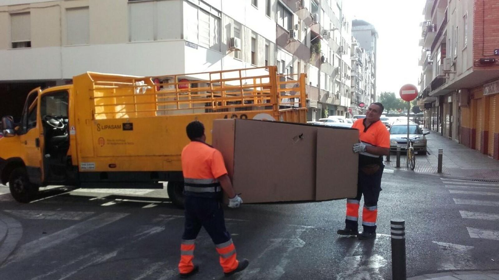 Dos operarios retiran un mueble.