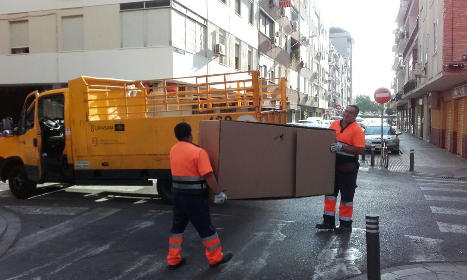 Dos operarios retiran un mueble.
