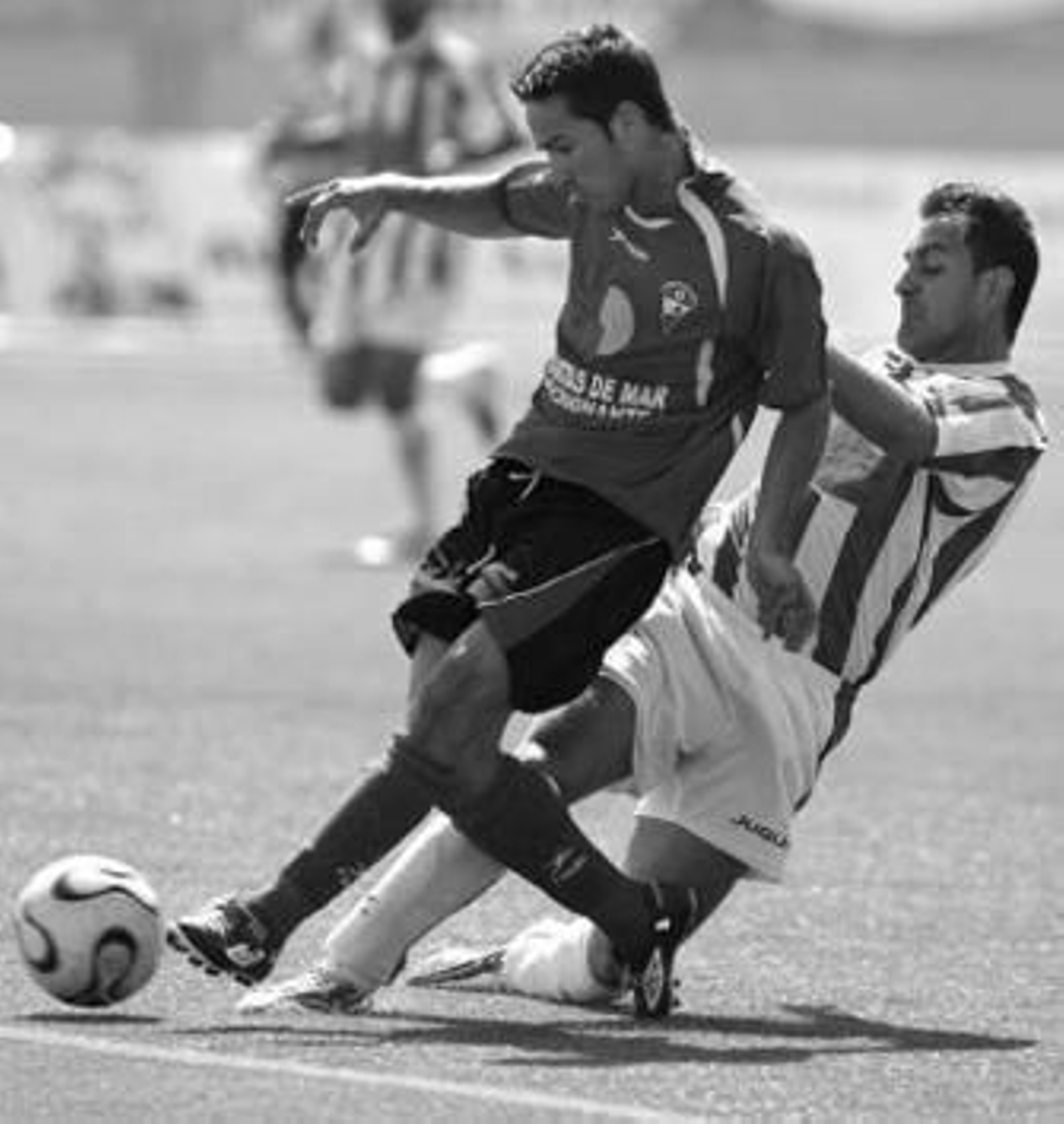 Un jugador del Catarroja hace una entrada a un roquetero.