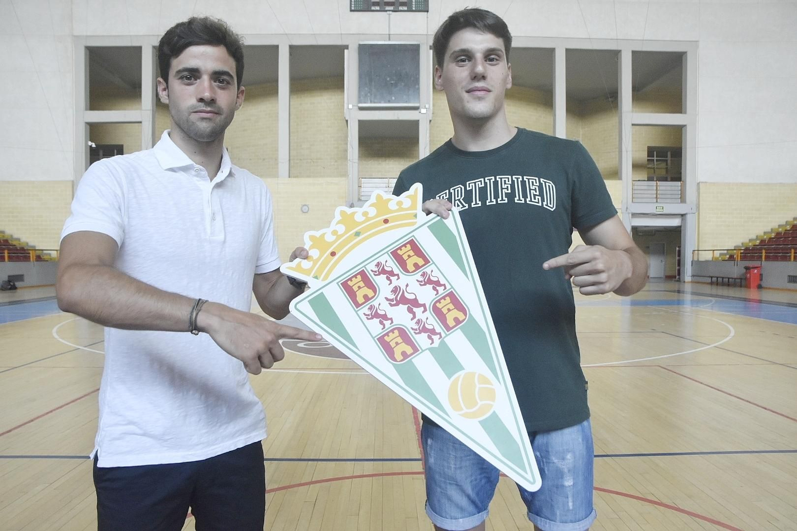 Pablo del Moral y Gonzalo posan con un escudo del Córdoba CF sobre la pista de Vista Alegre.