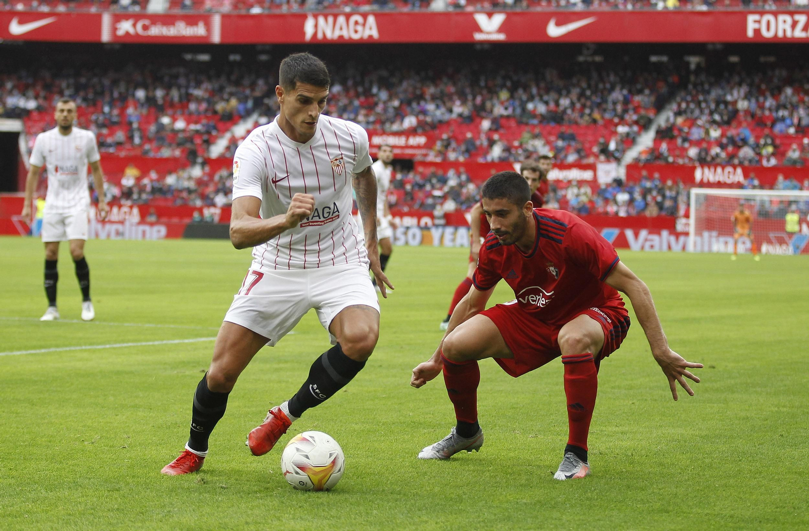 Lamela conduce la pelota con clase delante de Cote en el Sevilla-Osasuna.
