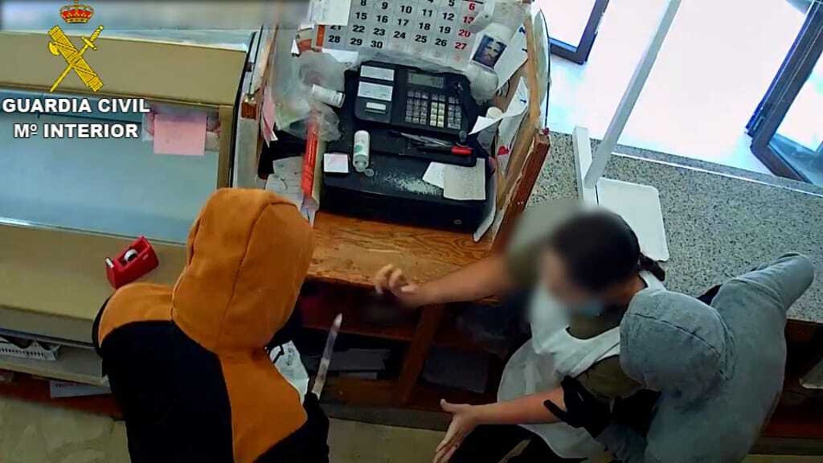 Momento en que los atracadores amenazan con un cuchillo a la trabajadora del establecimiento.