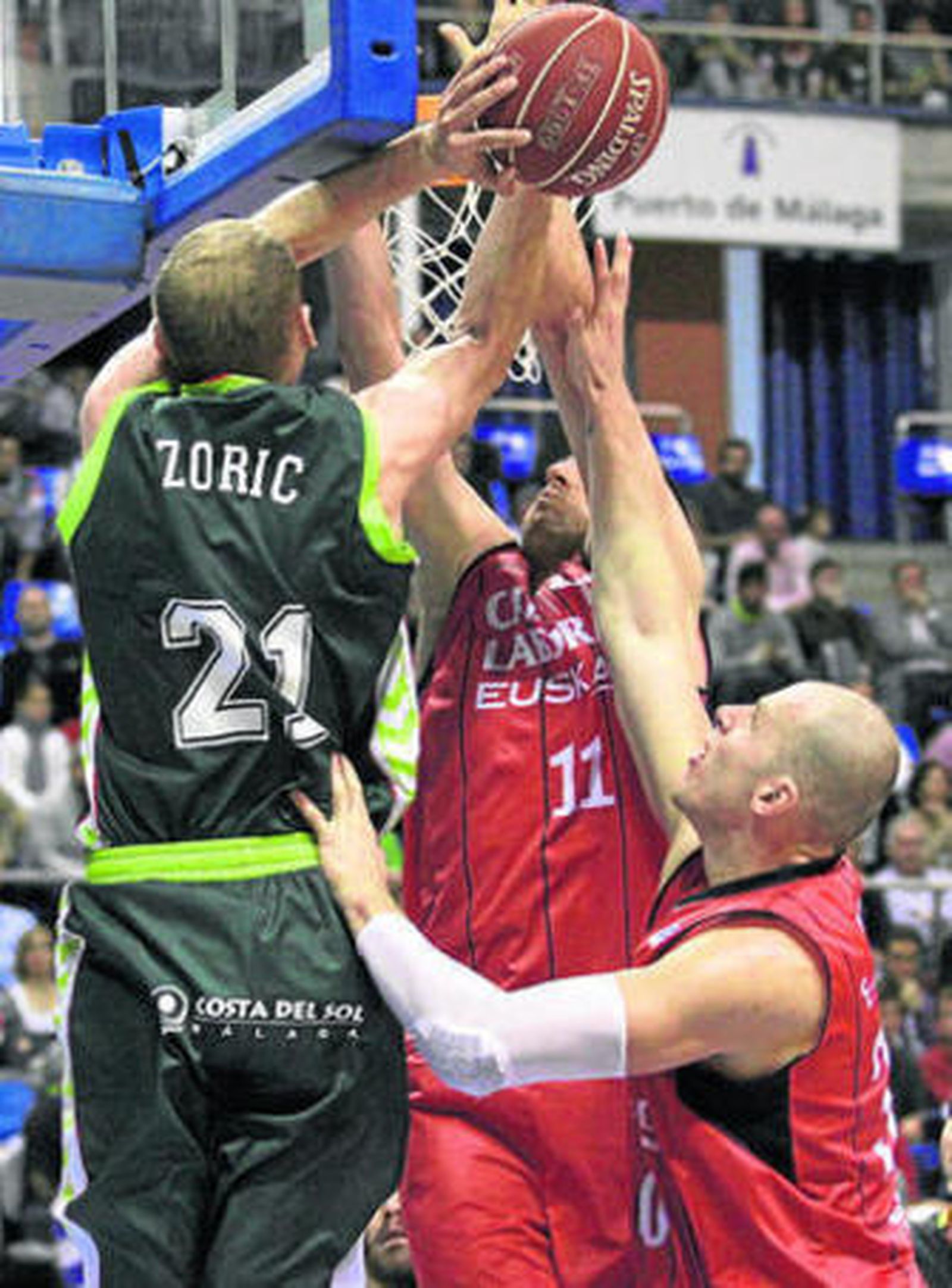 Zoric lanza bajo el aro ante la oposición de Milko Bjeliça y Lampe.