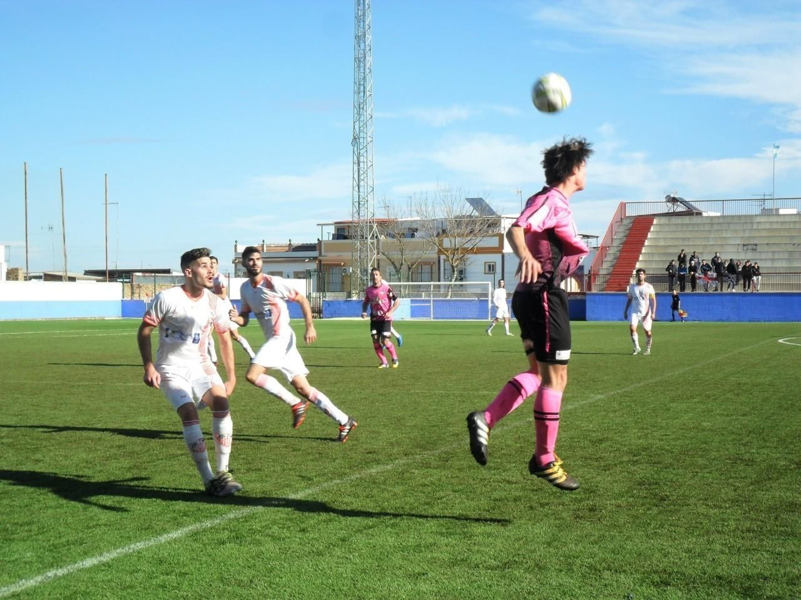 Varios jugadores de La Palma están atentos al cabeceo de balón por parte de un futbolista del cuadro visitante.