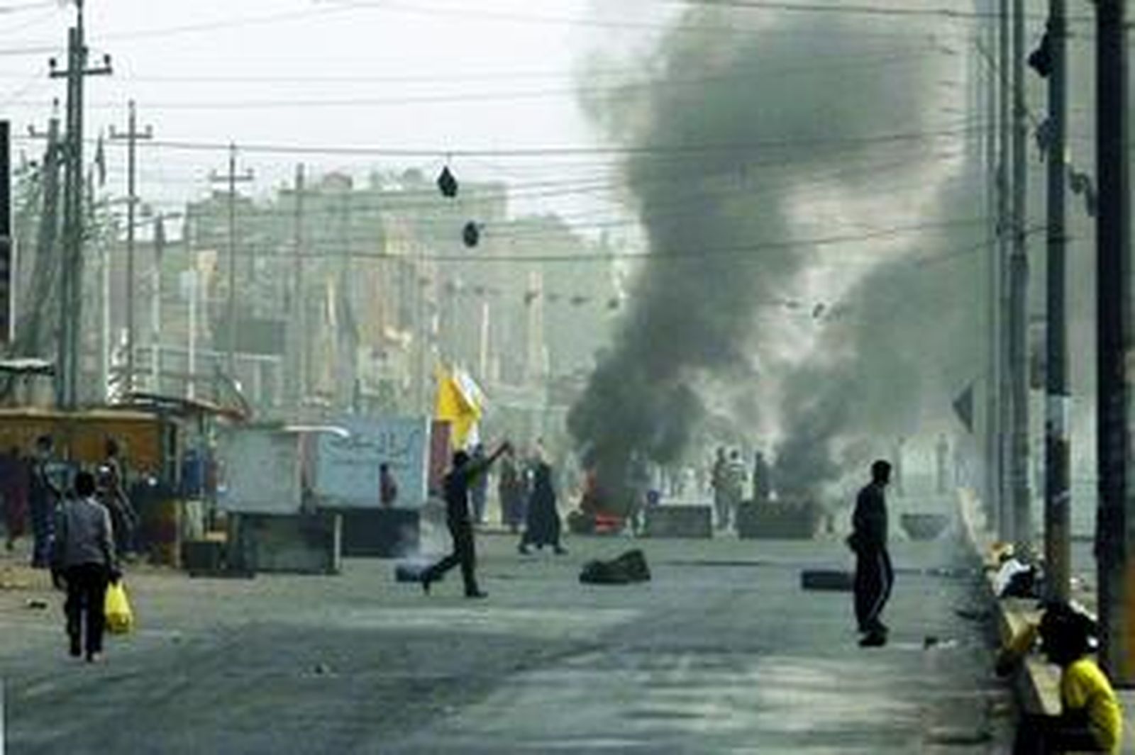 Milicianos del Ejército de Al Mahdi incendian neumáticos para cortar las calles en Ciudad Sadr, en Bagdad.
