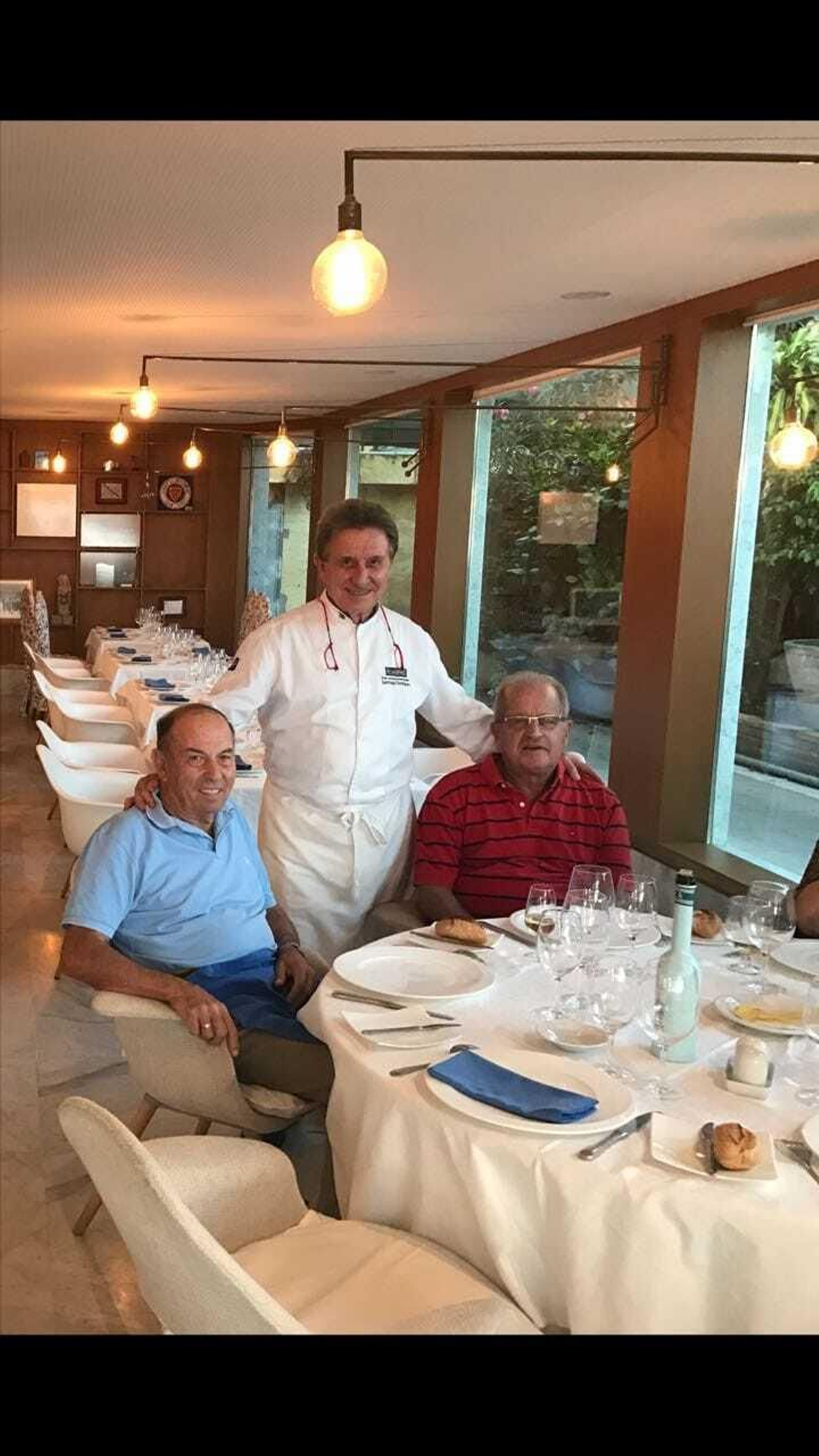 El restaurador Santiago Domínguez (c.) con unos clientes de la marisquería que regenta.