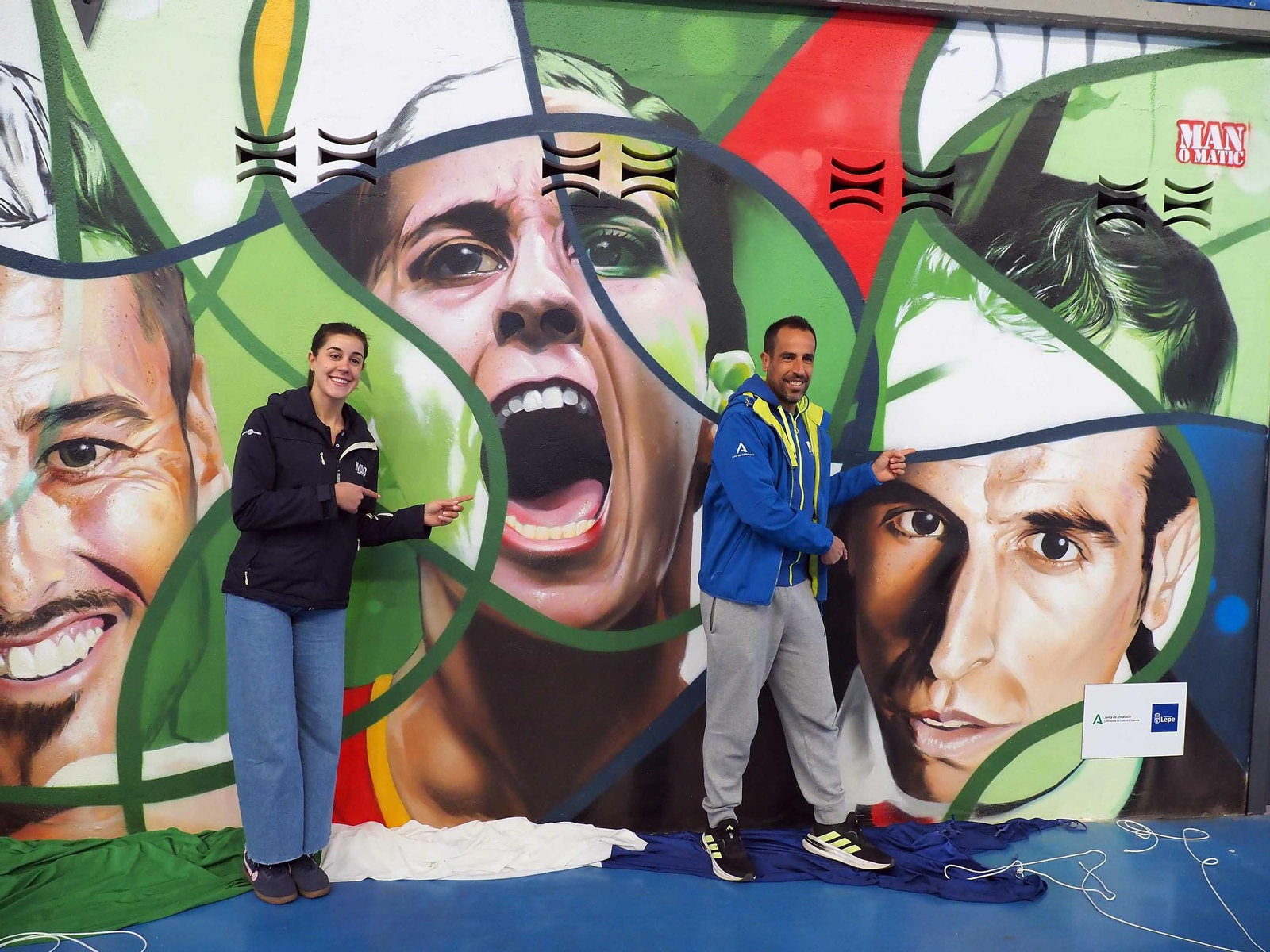 Carolina marín y Emilio Martín, ante el mural con sus rostros de Manomatic descubierto en el acto