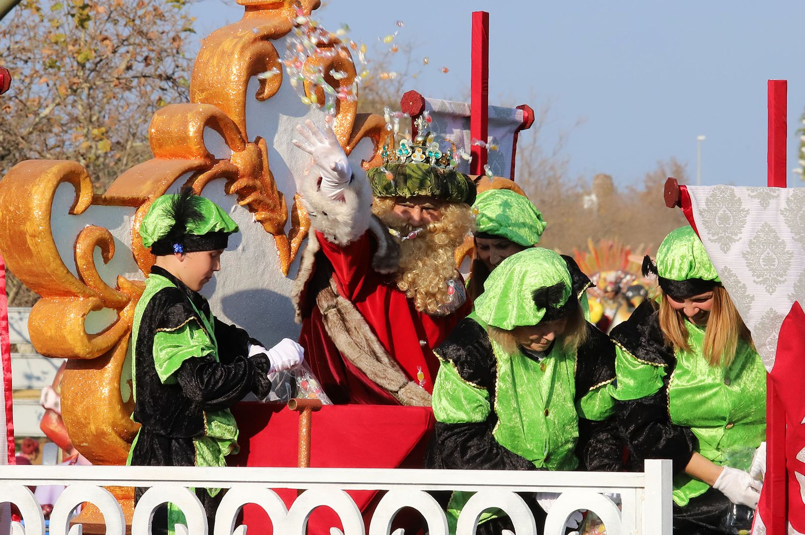 El rey Gaspar lanza caramelos durante la cabalgata.