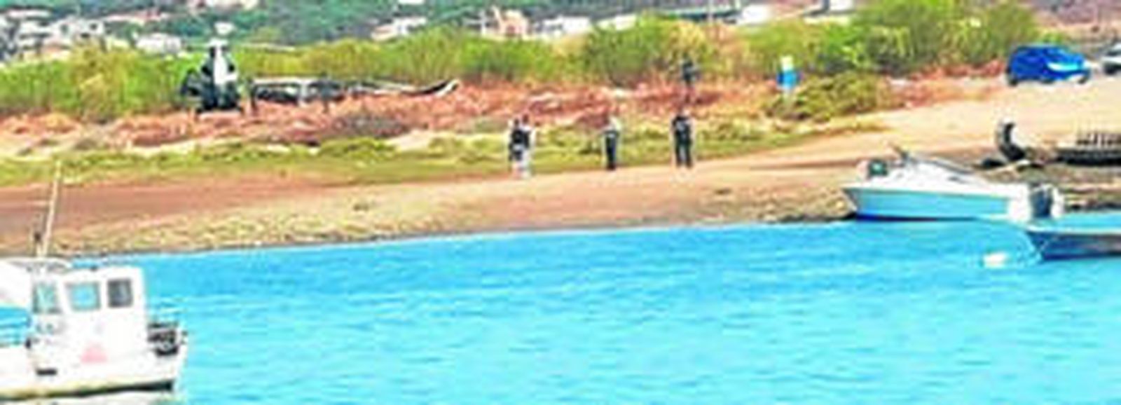 Al fondo, los investigadores y un helicóptero de la Benemérita; a la derecha del todo, la lancha blanca del alijo.