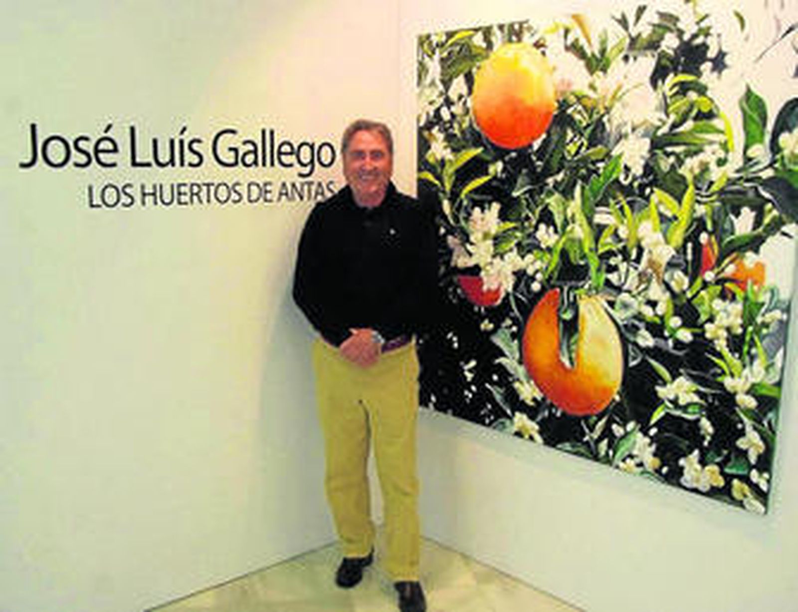 José Luis Gallego junto a la serie de pinturas donde aparecen los naranjos.