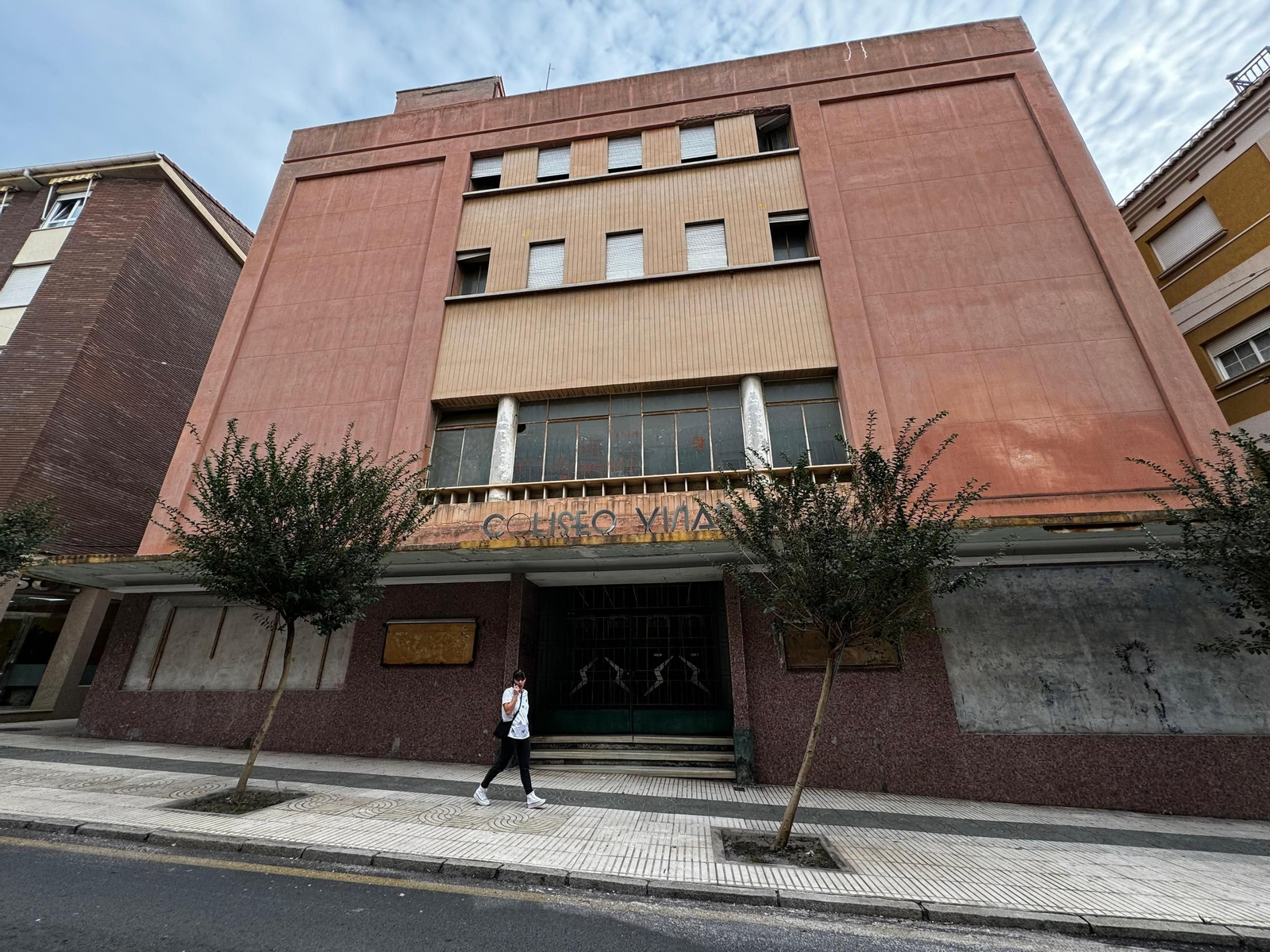 Una persona pasa por la puerta del Coliseo Viñas de Motril