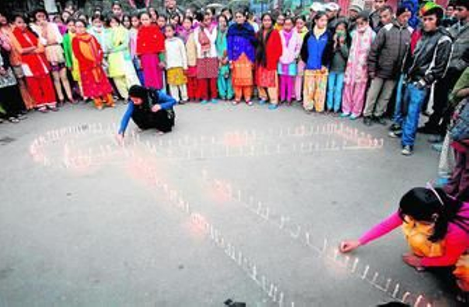 Un  grupo de niños de un orfanato de Nepal forman un lazo en una vigilia celebrada en la víspera del Día mundial contra el sida, que se celebra hoy.