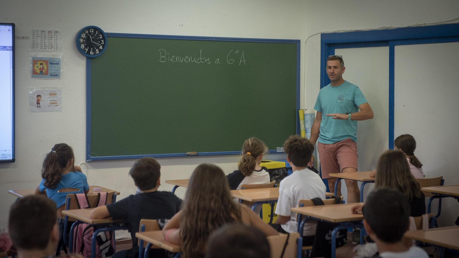 Un maestro recibe a sus alumnos en el CEIP Escritor Alfonso Grosso.