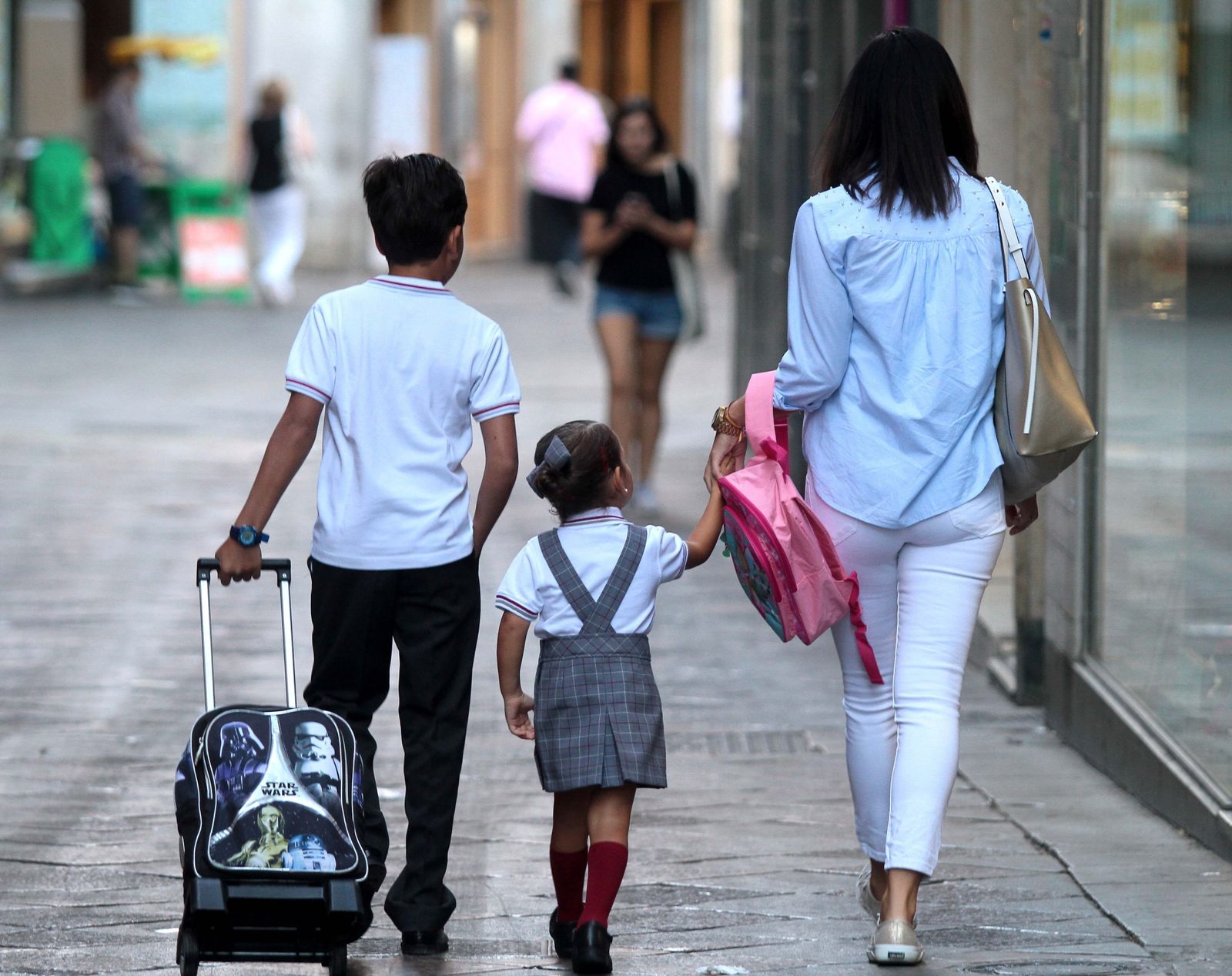 Una madre recogiendo a sus hijos tras las clases.