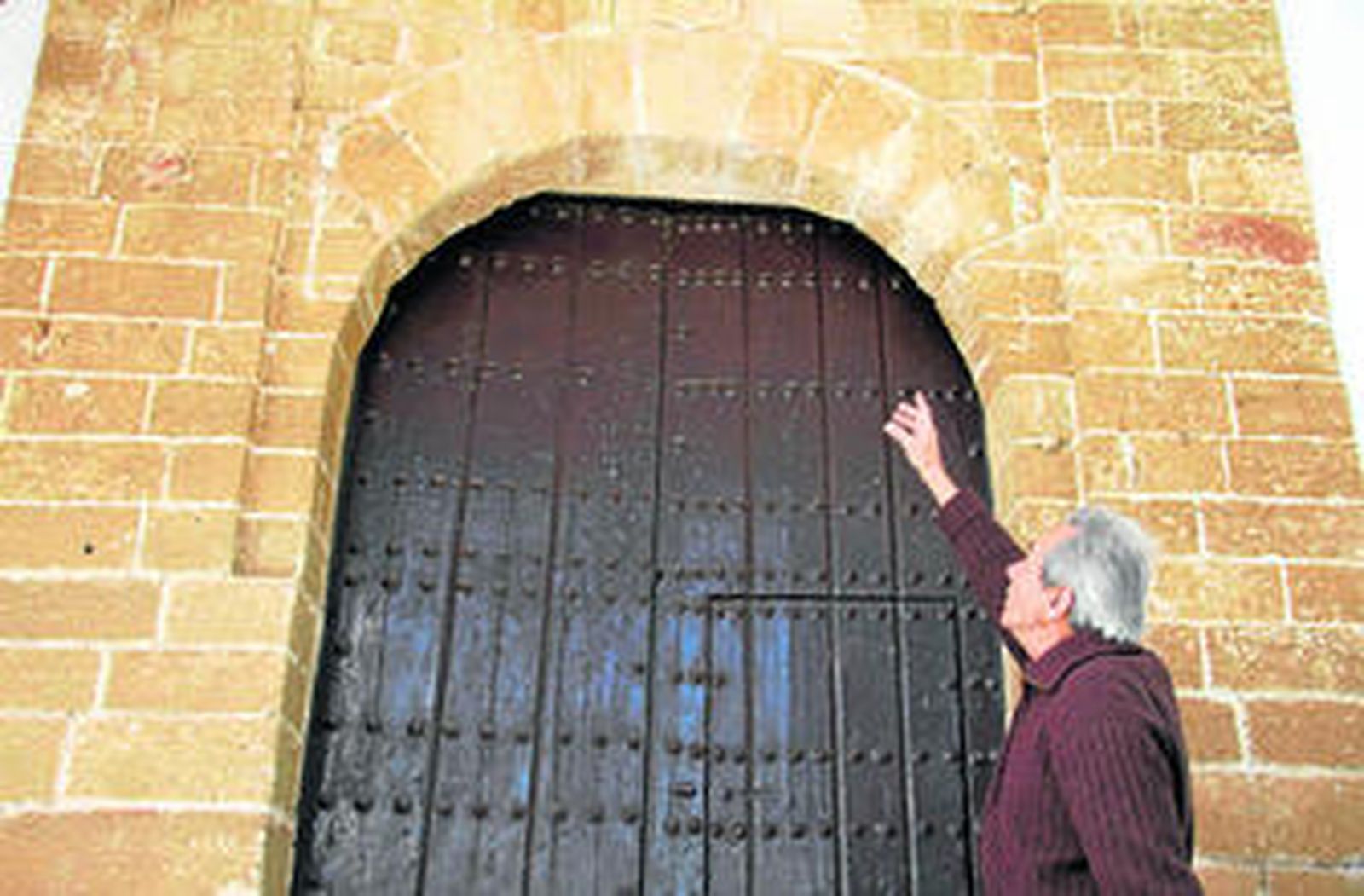 El ermitaño Carlos García de Paredes, delante de la puerta de acceso al templo ubicado en el término municipal de Medina Sidonia.