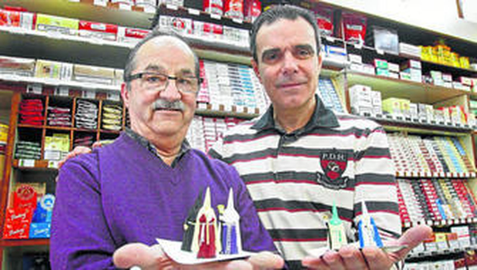 Álvaro y Fernando López muestran en el Estanco Avenida algunos de los penitentes que sortearon a cambio de alimentos para el comedor benéfico.