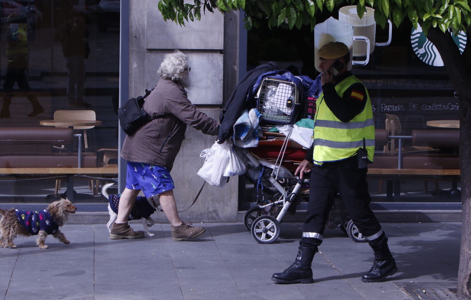 Un hombre sin hogar empuja un carro con sus pertenencias.