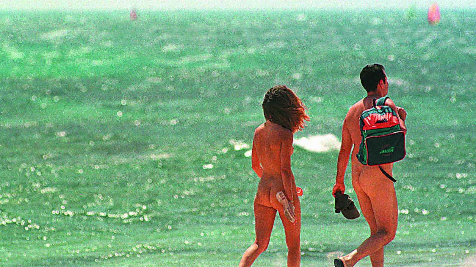 Dos nudistas pasean por la orilla de la playa de Bolonia, en Tarifa