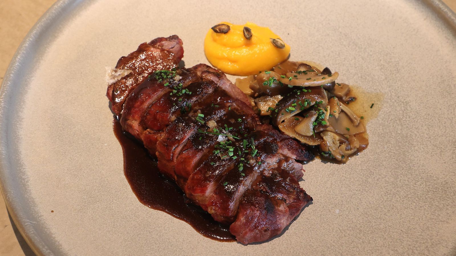 Solomillo de cerdo lacado en tamarindo servido con puré de jengibre y calabaza.