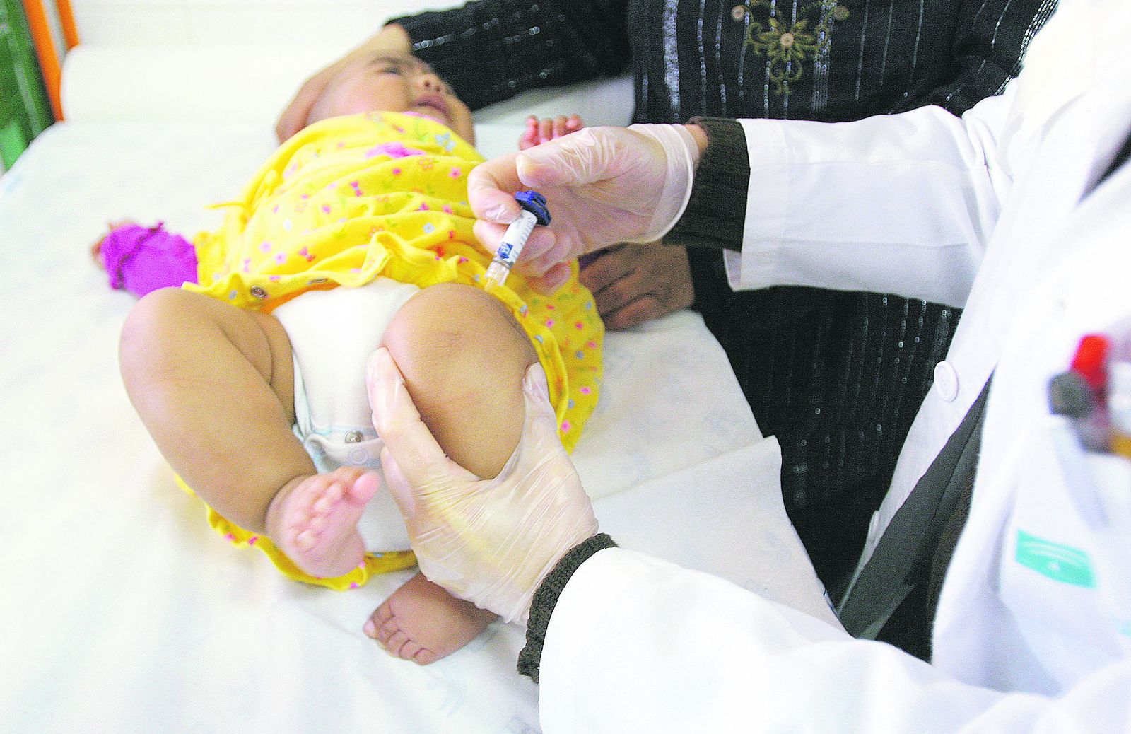 Una pediatra vacuna a un bebé.