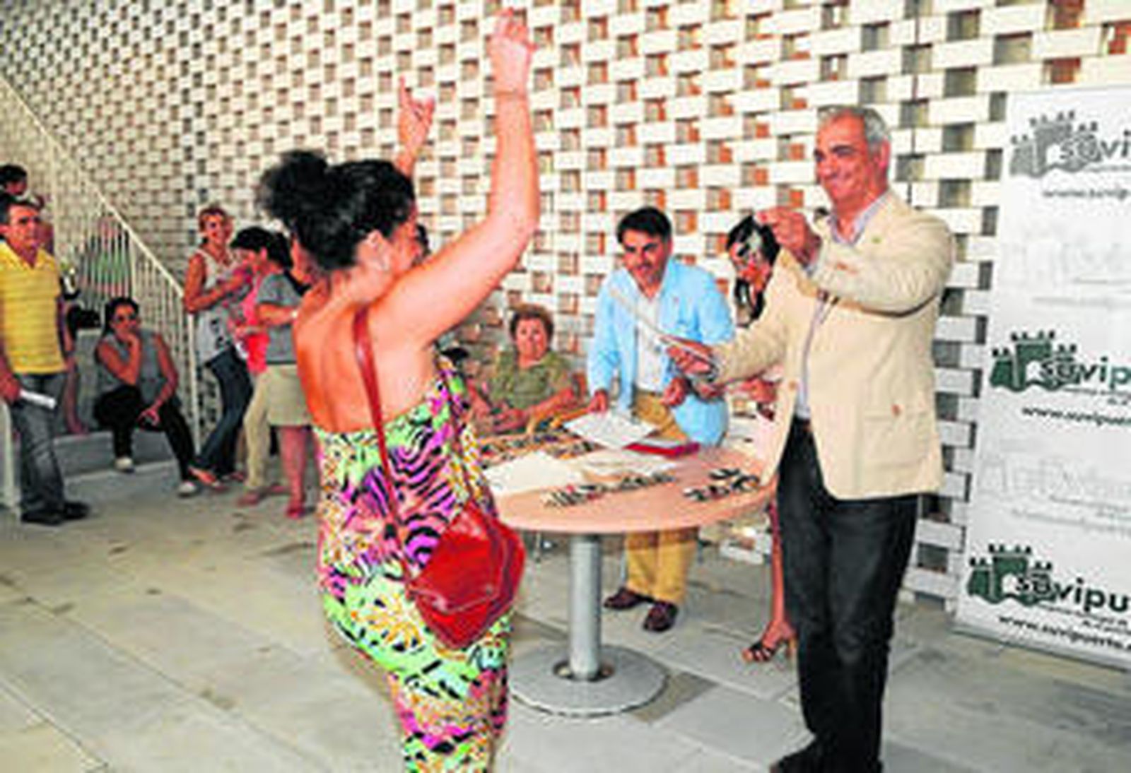 Una de las adjudicatarias se marca un baile en el momento de recibir las llaves de manos del concejal.