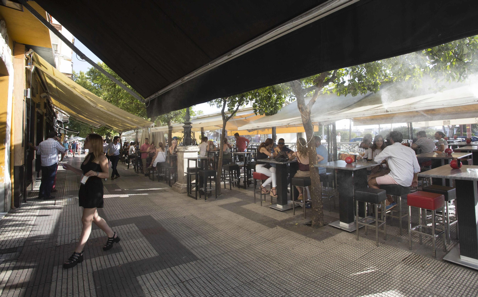 Varias personas toman bebidas en las  terrazas del Paseo Colón.