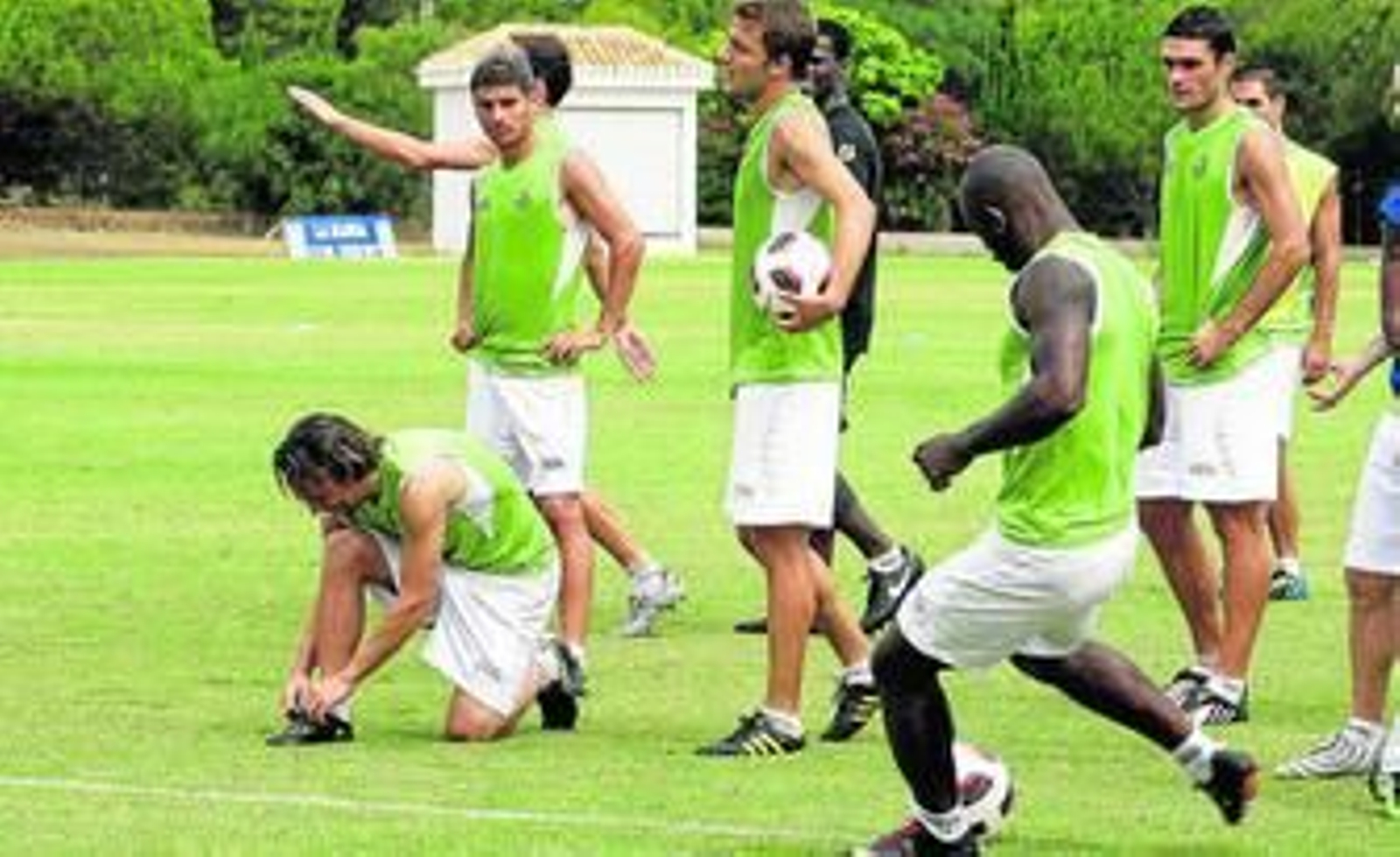 Emana dispara a puerta mientras Sergio García se amarra la botas durante el entrenamiento de ayer.
