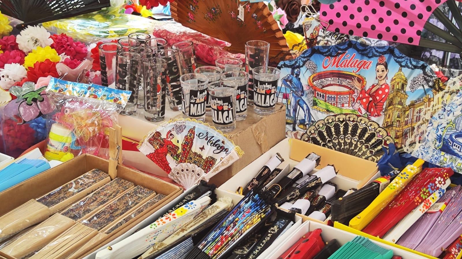 Abanicos, flores y vasos en un puesto de la Feria de Málaga.