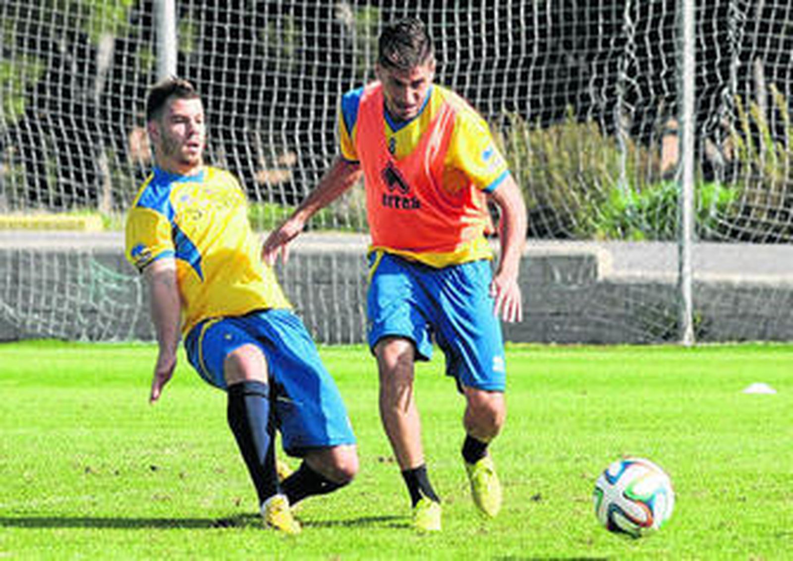 Juanma Espinosa se lleva el esférico en presencia de Kike López.