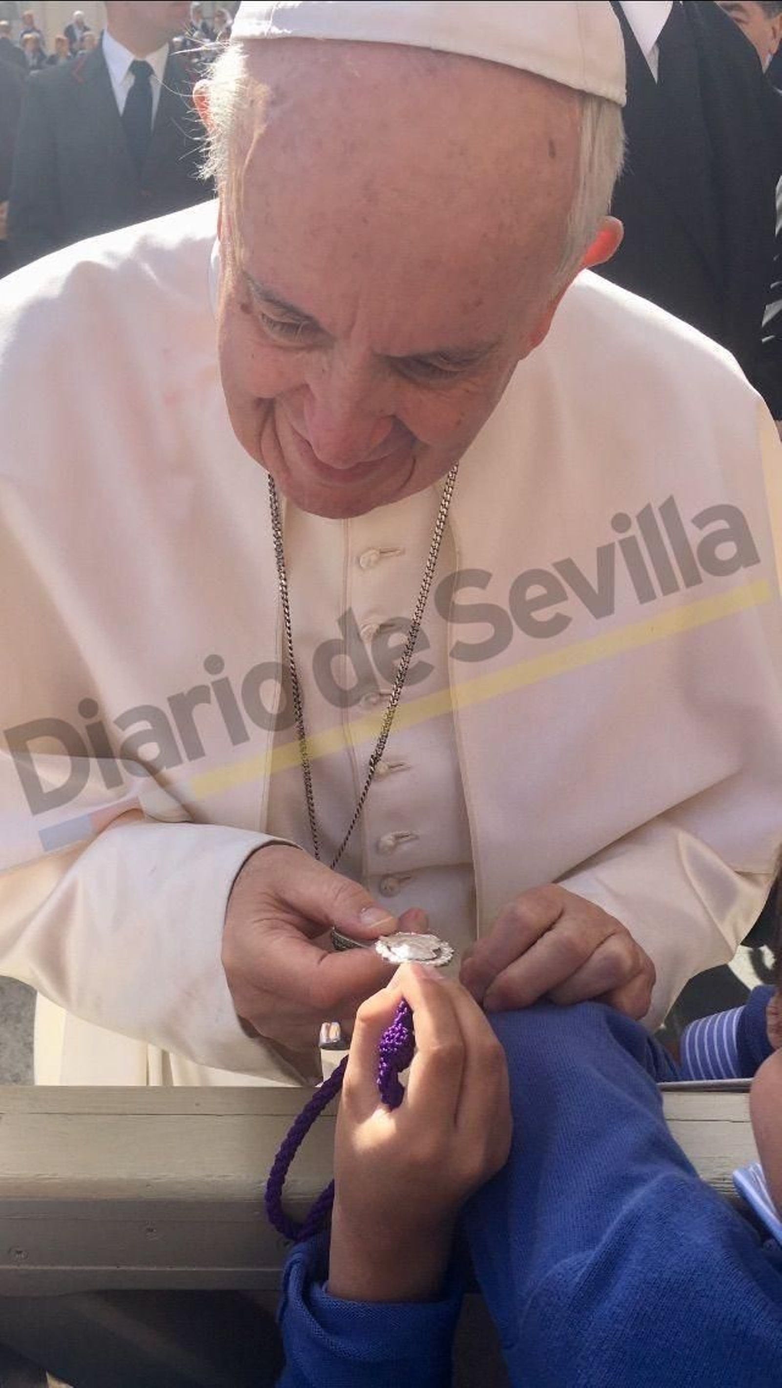 Las manos del Papa reciben la medalla