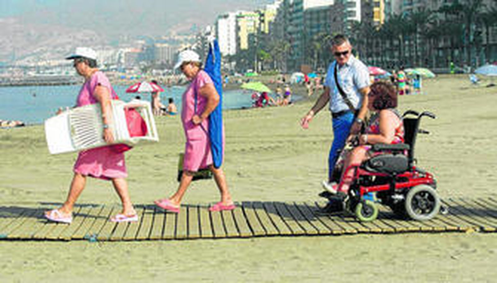 Una discapacitada recorre una pasarela de madera en la playa del Zapillo en Almería, en una imagen reciente.