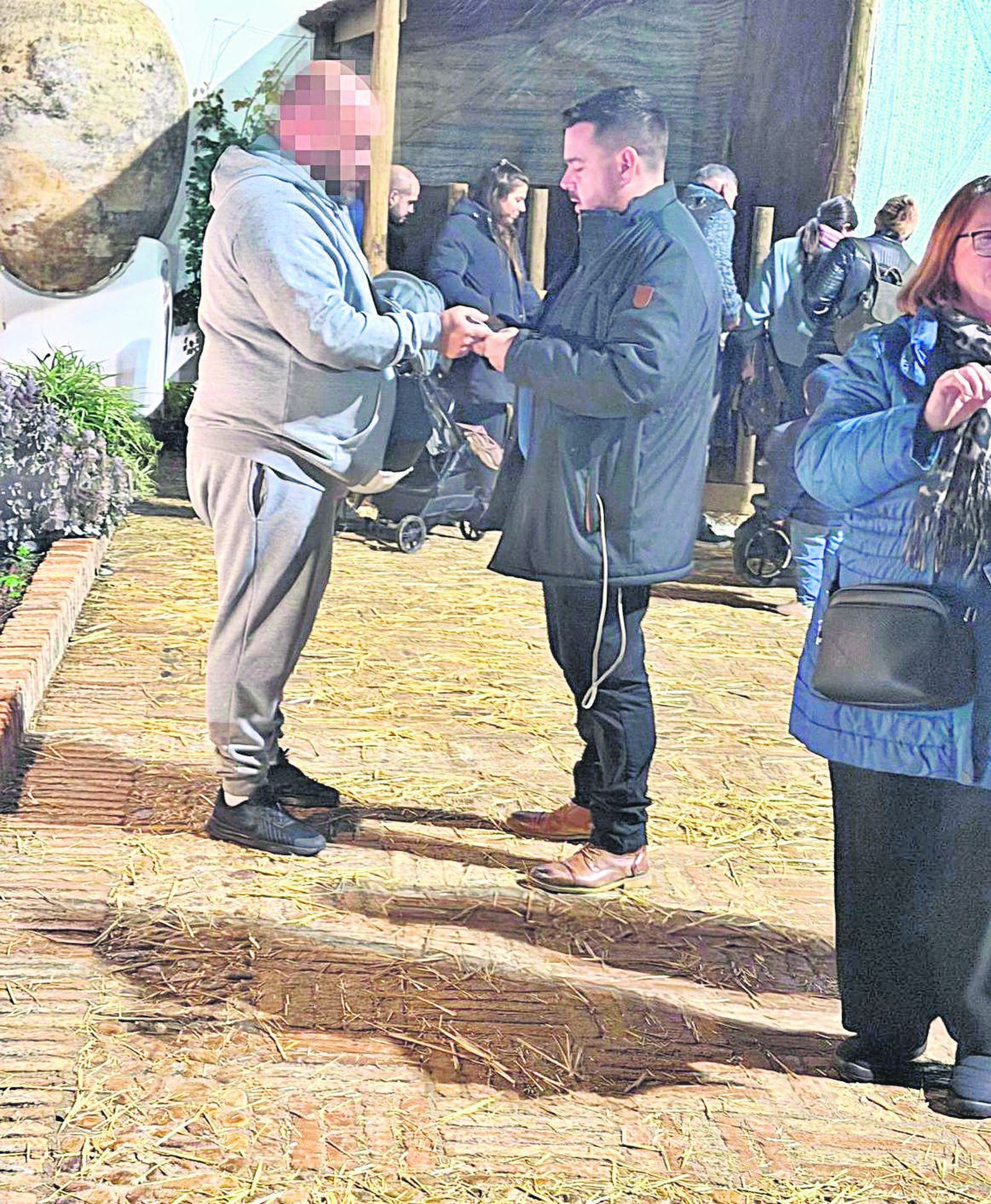 Un empleado del Green House entrega un objeto al alcalde de Gines, Romualdo Garrido, quien niega que se trate de una mordida.