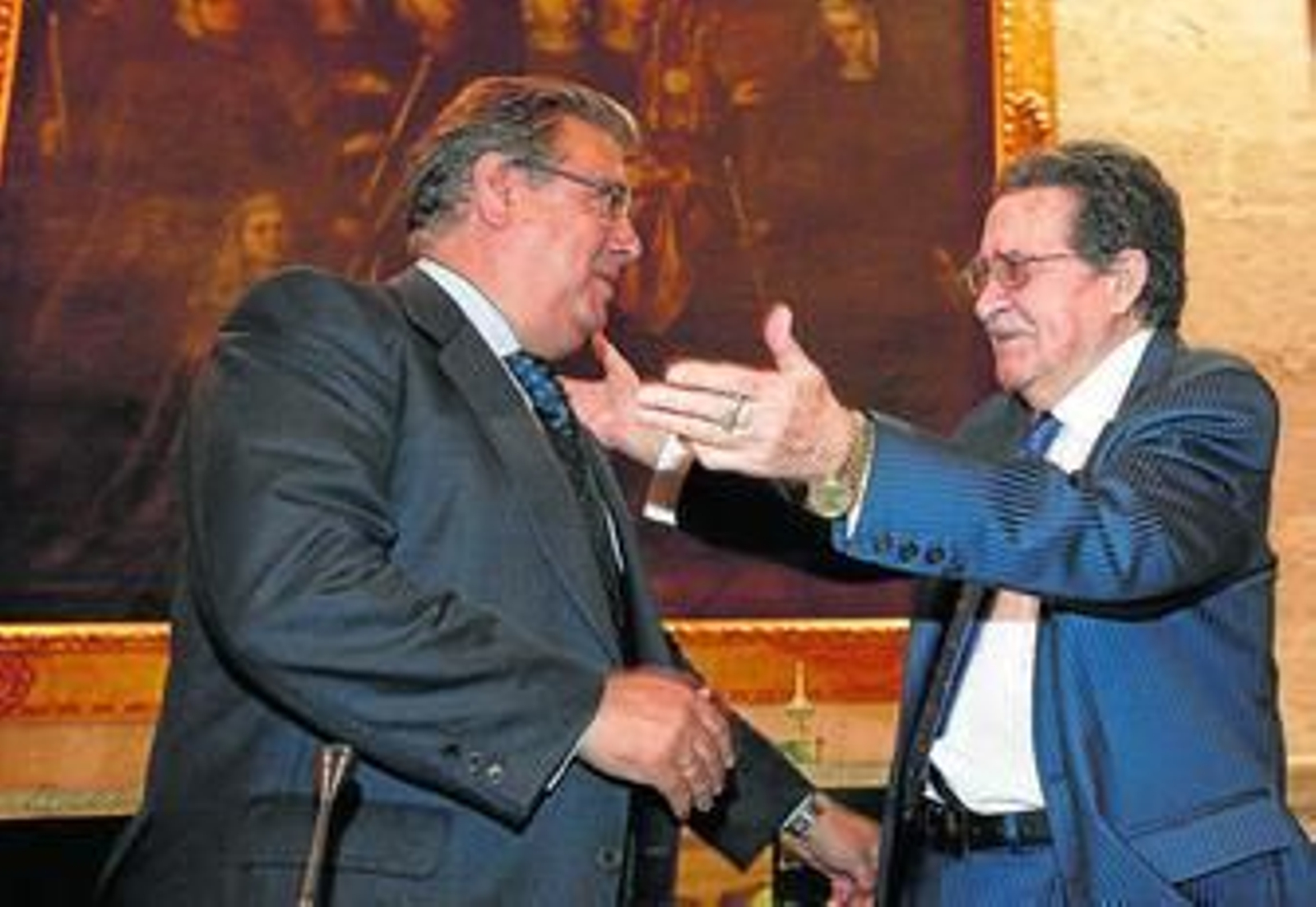 Mariano Bellver tiende los brazos al alcalde de Sevilla durante el acto celebrado ayer en el Consistorio.