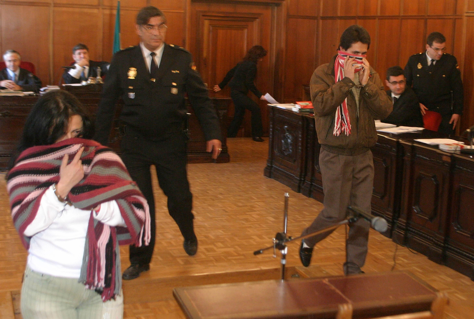 R. S. A. se tapa la cara con una bufanda durante el juicio por el asesinato del taxista.