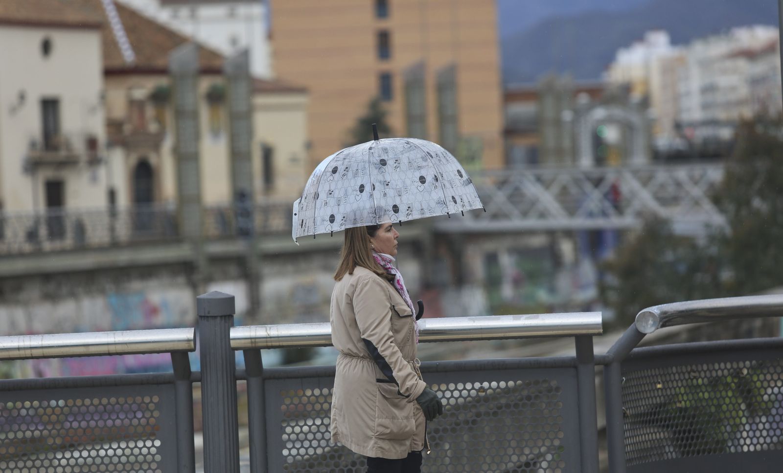 Una mujer se resguarda bajo su paraguas del temporal.
