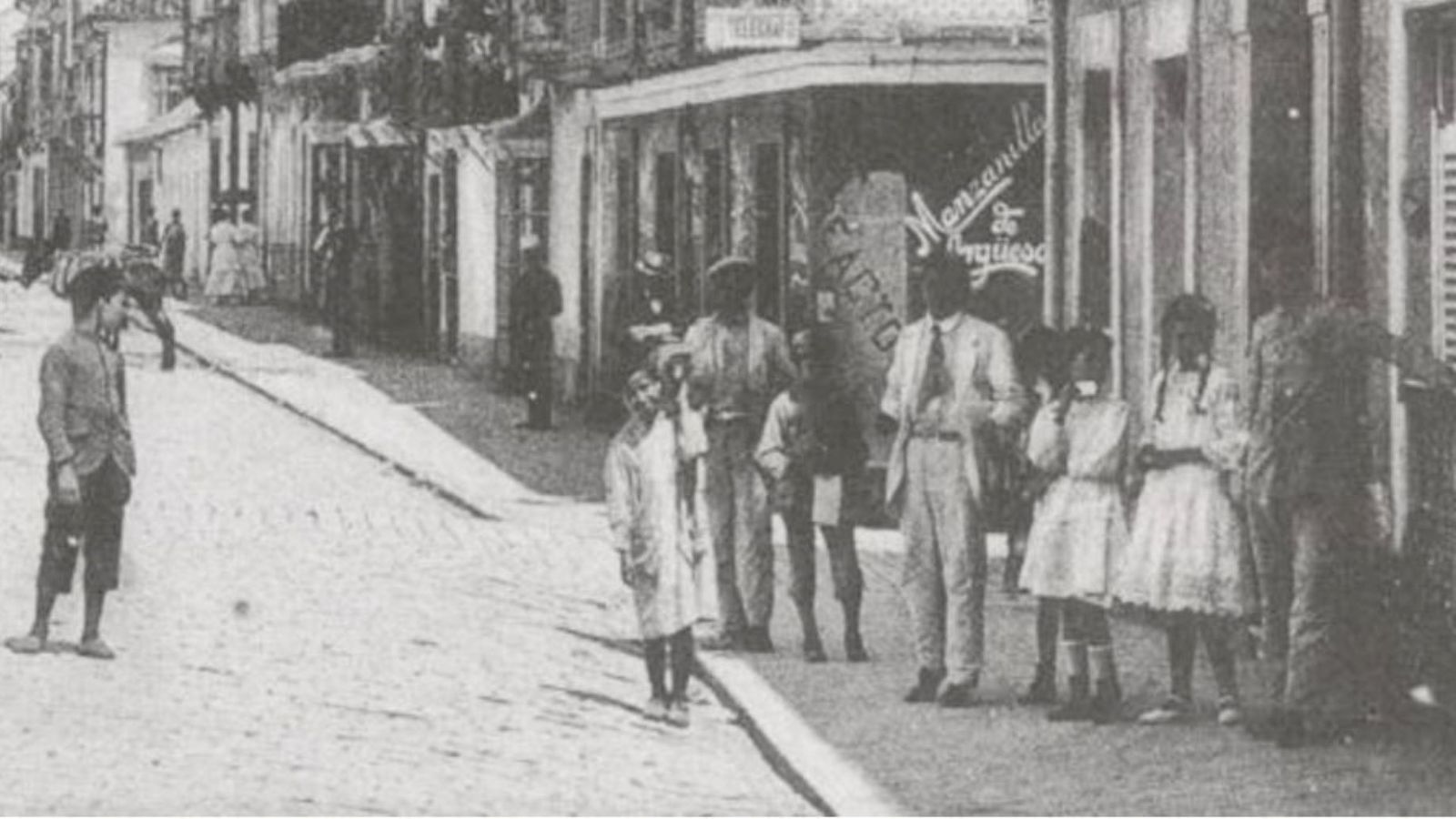 Un niño recadero, junto otro menor de la calle y niñas de la burguesía local.