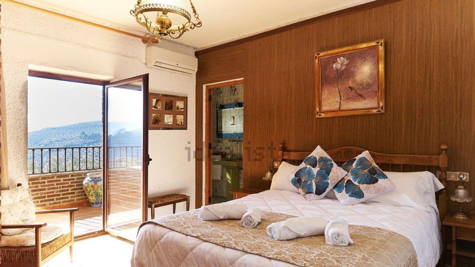 Uno de los dormitorios del inmueble, con vistas al mar de olivos.