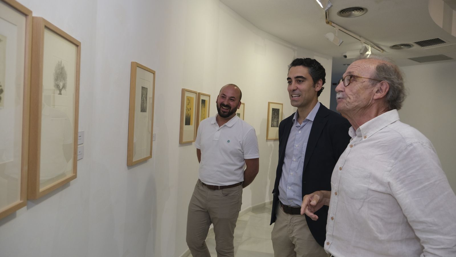 El concejal Joaquín Pérez de la Blanca con Restituto López viendo la exposición.