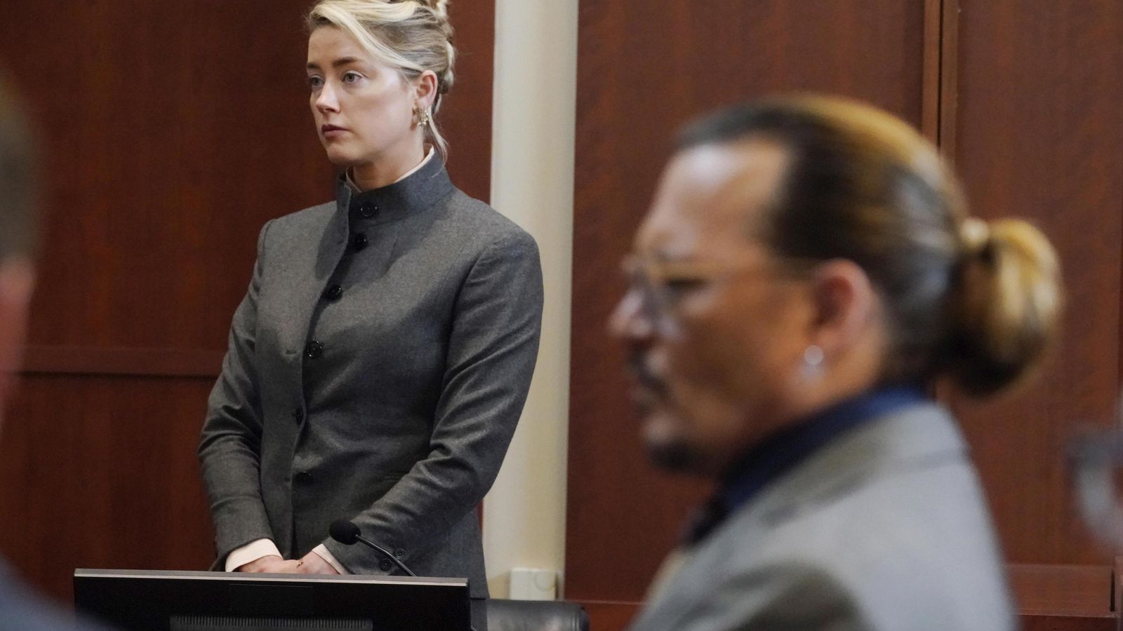 Amber Heard, antes de comenzar su testimonio en el tercer día de juicio. En primer plano, Johnny Depp.